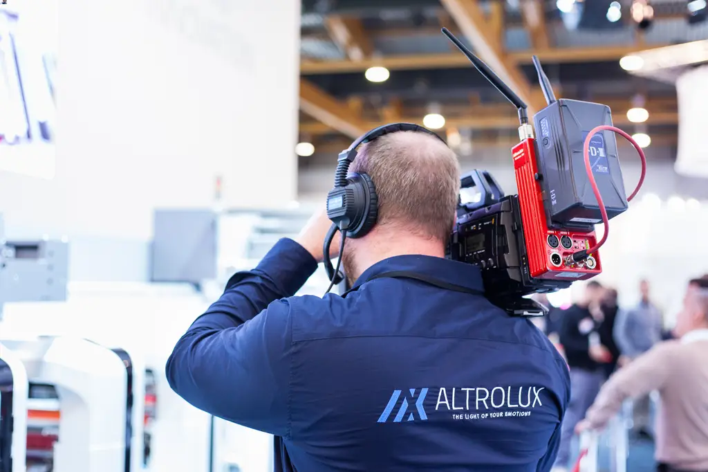 a man wearing headphones and a large camera on his back